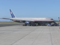N215UA @ PHNL - UAL 777 on ramp at Honolulu. Maint pers are changing left engine. - by John J. Boling