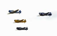 - SNJ and T6 formation overflight , John Z. leads followed by Jack C., Gary M., and Julie S.  - great formation group. Overexposed since photo was shot so late in evening towards the sun - by John Little