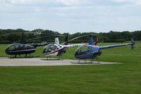  - Robinson R44 and R22's outside the Heliair hangar - by Chris Hall