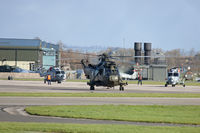  - A view across the helicopter pan with several Lynx HMA8s and a Sea King HC4 heading out.  Visible behind are two stored Sea Harrier Fa2s and the FAA Museum to the left. - by Howard J Curtis